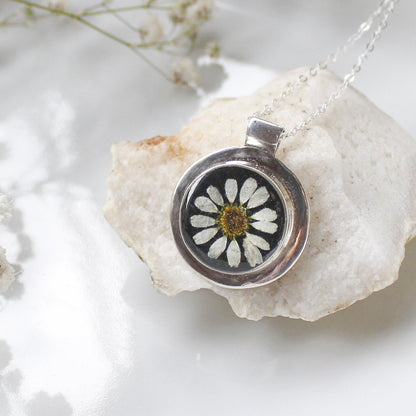 Silver pendant with a pressed flower on a white stone